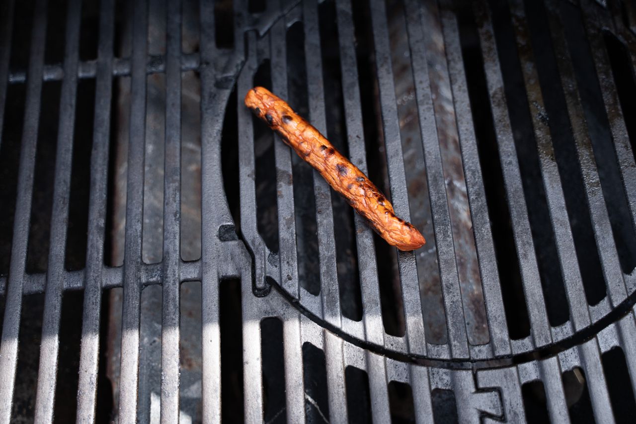 Spirs plantebaserede pølse opførte sig som en grillpølse lavet af kød, da både skind og indhold lignede den animalske udgave. Foto: Thomas Schønning. Plantebaseret pølse ligger på grill med sprækket skind.
