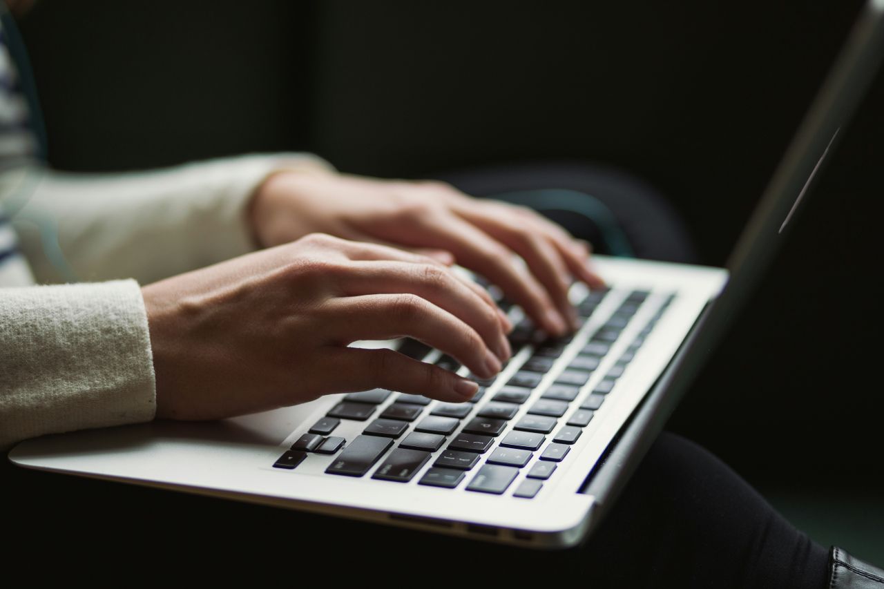 Kvindehænder på tastatur på bærbar computer